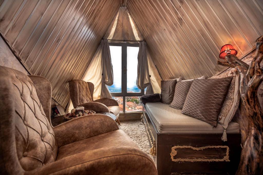 een woonkamer met een bank en stoelen in een tent bij Lykovrisi Guest House in Arachova