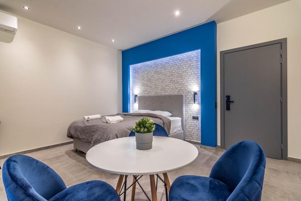 a bedroom with a white table and blue chairs at Historic Center Apartment 3 in Athens
