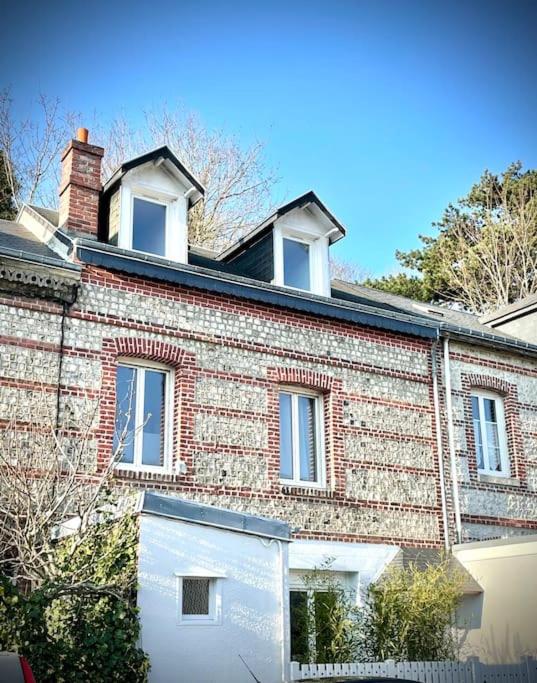 un grand bâtiment en briques avec un garage blanc dans l'établissement Etretat: agréable maison de ville, à Étretat
