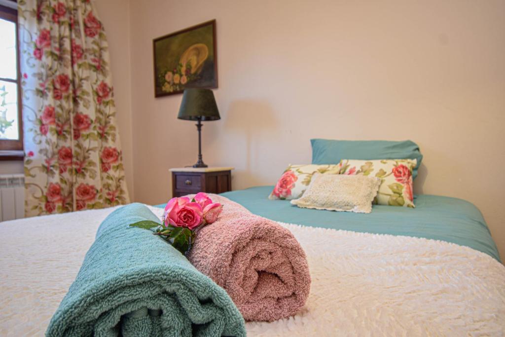 ein Schlafzimmer mit einem Bett mit einer rosa Blume darauf in der Unterkunft Casa das Rosas in Sintra