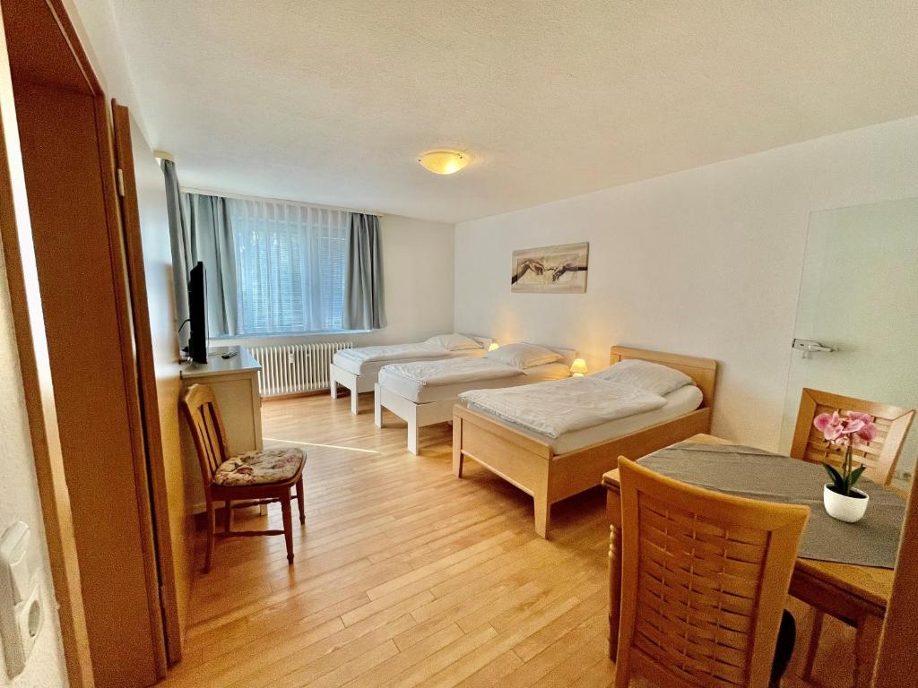 Habitación de hotel con 2 camas, mesa y sillas en Apartment für vier, en Hannover