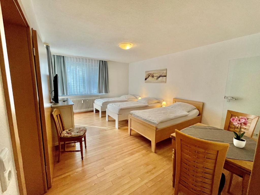 a hotel room with two beds and a table and chairs at Apartment für vier in Hannover