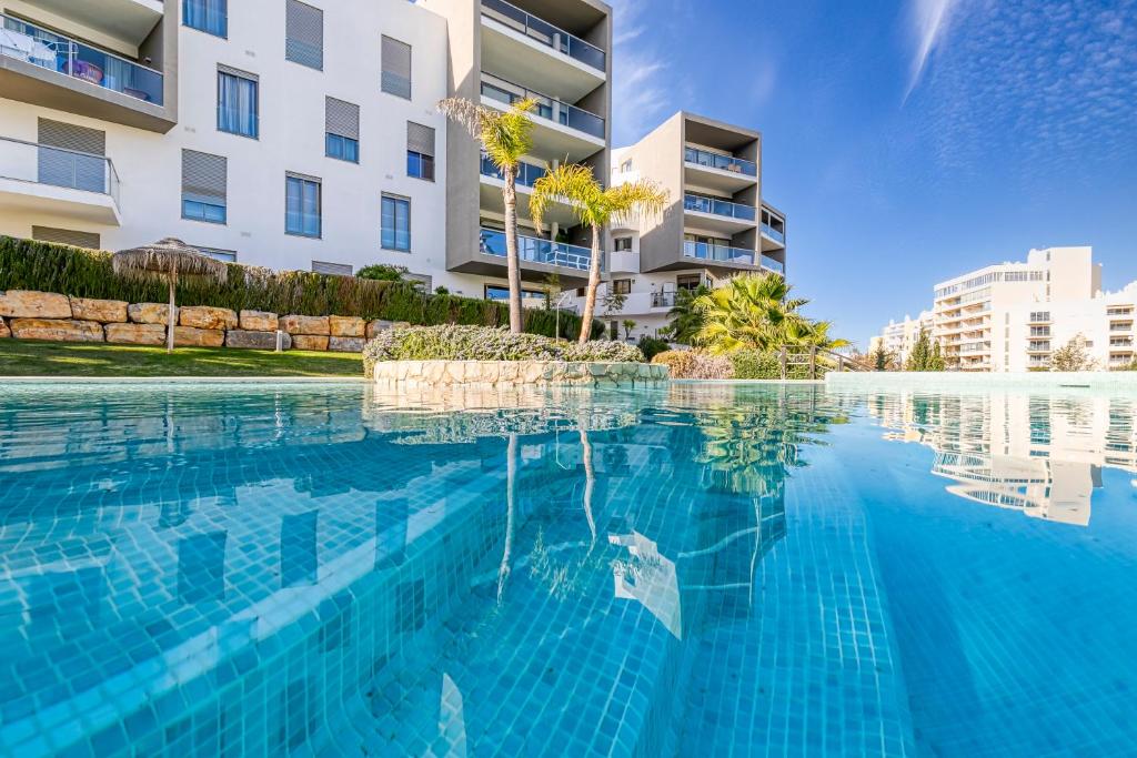 a swimming pool in front of a building at Casa Rosa in Fabulous Portimão in Portimão