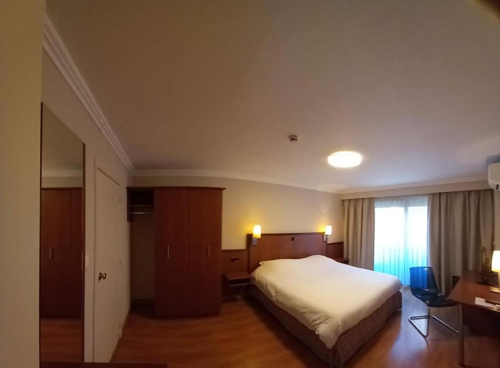 ein Hotelzimmer mit einem Bett und einem Fenster in der Unterkunft Hotel De Croone in Ninove