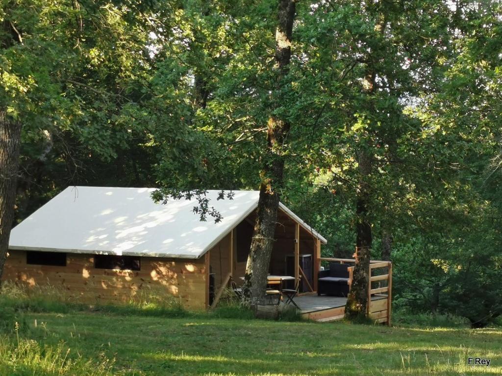 a log cabin in the middle of a field with trees at Drome esprit nature in Le Poët-Célard