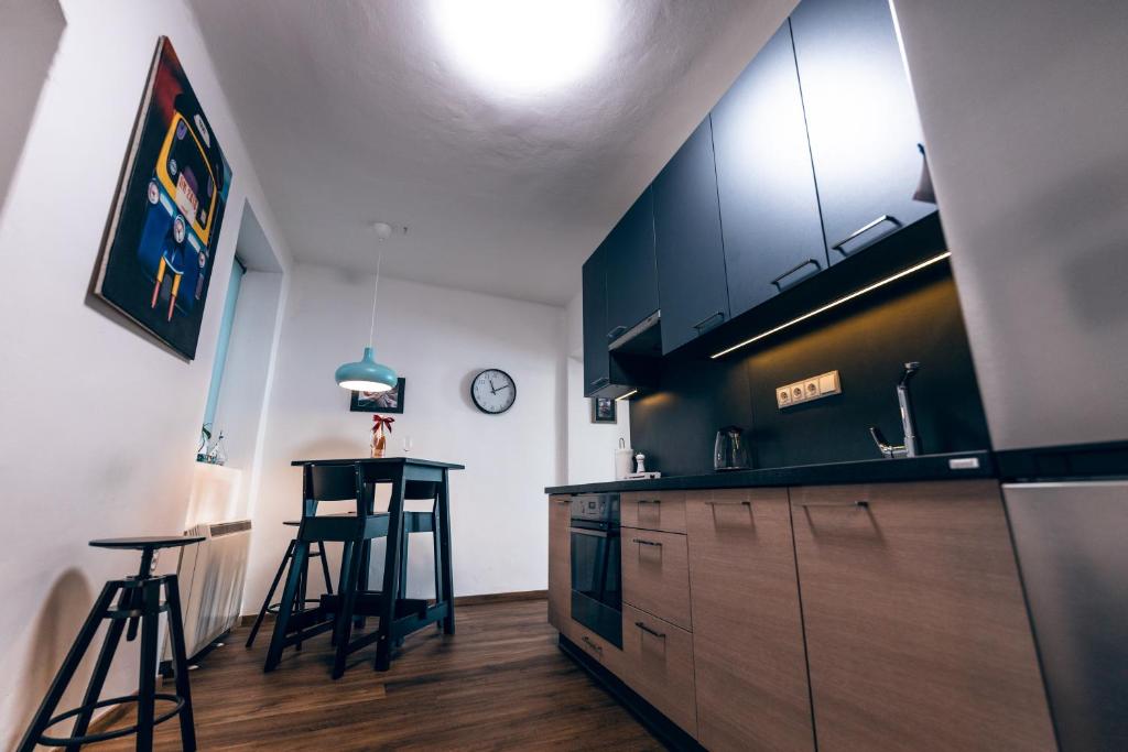 a kitchen with a counter and stools in a room at Apartmány CAFÉ-CAFÉ in Jičín