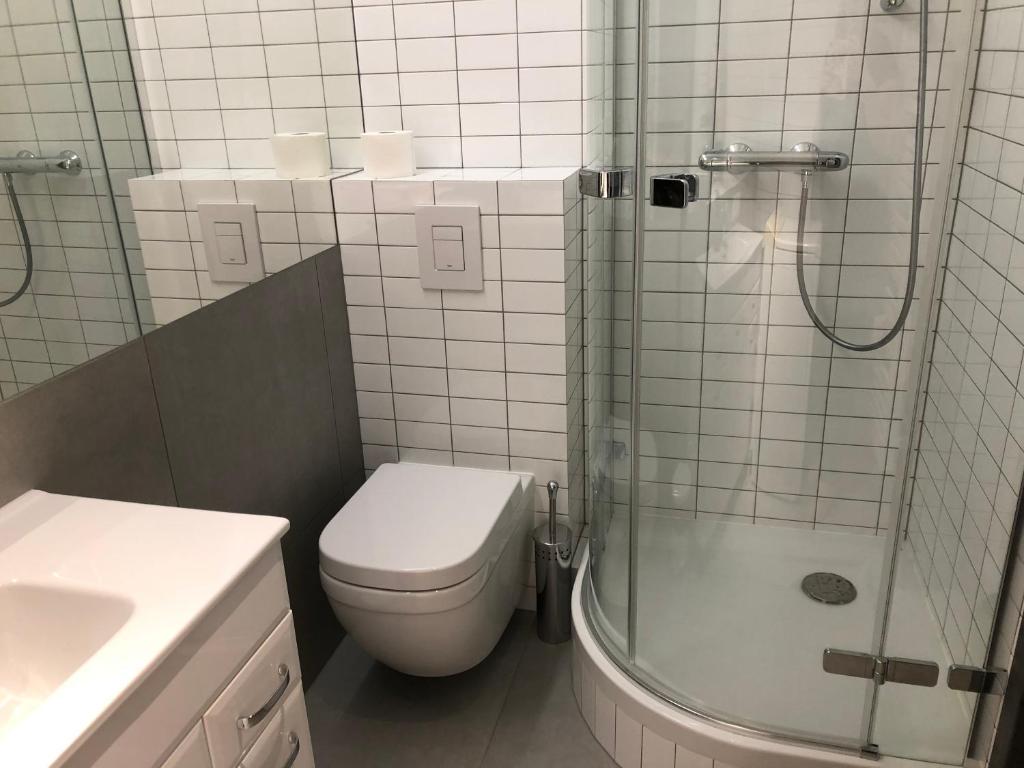 uma casa de banho com um WC, um chuveiro e um lavatório. em Apartament Dora em Poznań