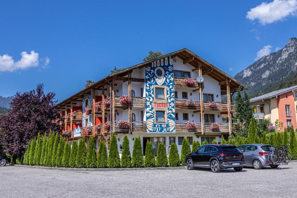 ein Gebäude mit davor geparkt in der Unterkunft Alpenhotel Brennerbascht in Bischofswiesen