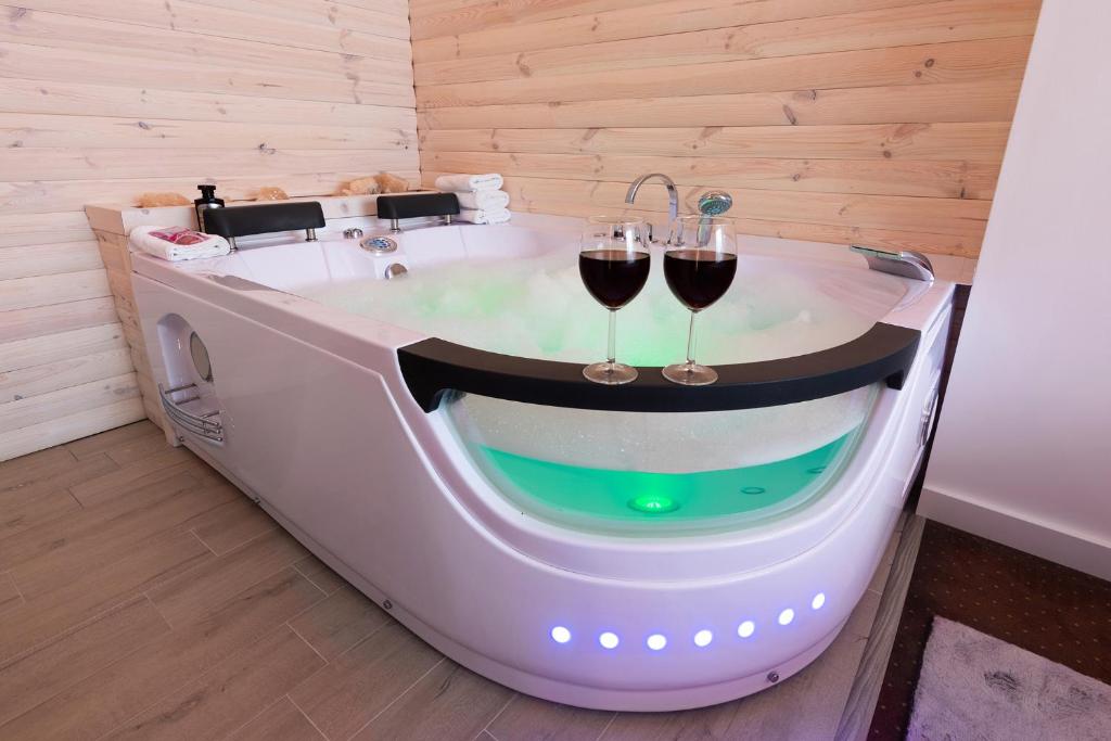 a bath tub with two glasses of wine in it at Luna De Luxe Apartment in Michałowice