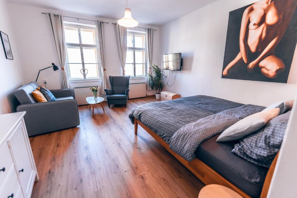 a bedroom with a bed and a living room at Apartmány CAFÉ-CAFÉ in Jičín
