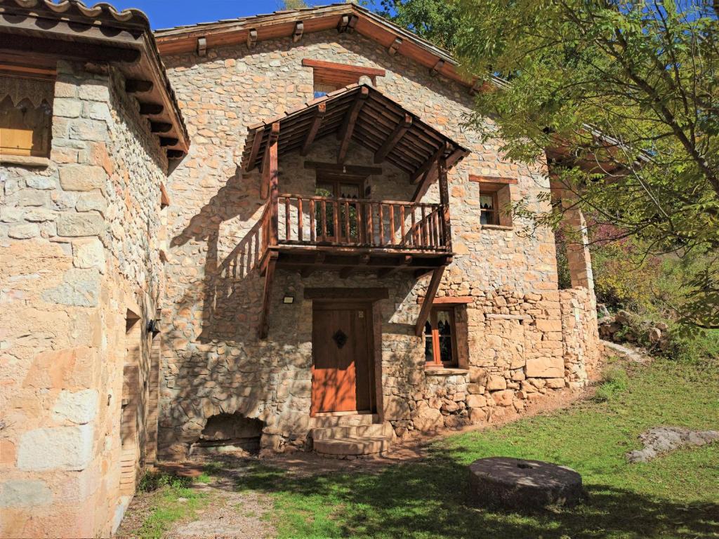 an old stone building with a balcony on it at Molí de Dalt in La Coma i la Pedra