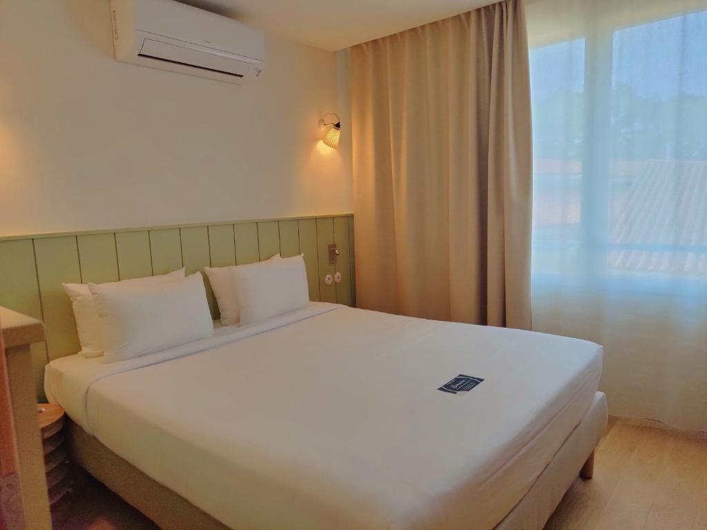 Postel nebo postele na pokoji v ubytování Hôtel Les Grenettes
