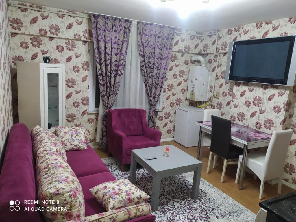 a living room with a purple couch and a table at Üsküdar halk caddesi in Istanbul