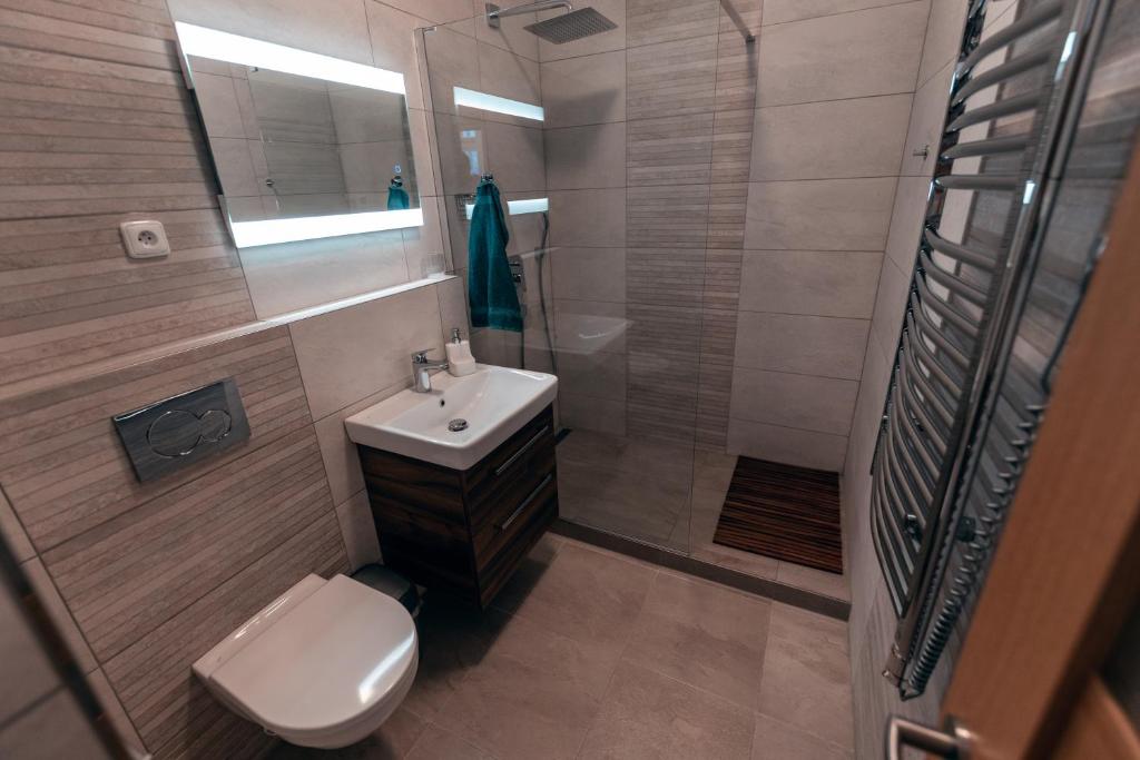 a bathroom with a toilet and a sink and a shower at Apartmány CAFÉ-CAFÉ in Jičín