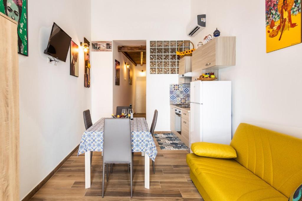 een keuken en eetkamer met een tafel en een bank bij Casa Emma in Avola