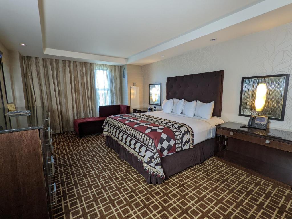 ein Hotelzimmer mit einem großen Bett und einem Stuhl in der Unterkunft Miccosukee Casino &amp; Resort in Miami