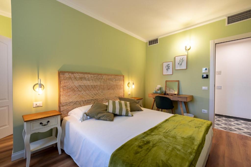 sypialnia z dużym białym łóżkiem i biurkiem w obiekcie B&B Follonica w mieście Follonica