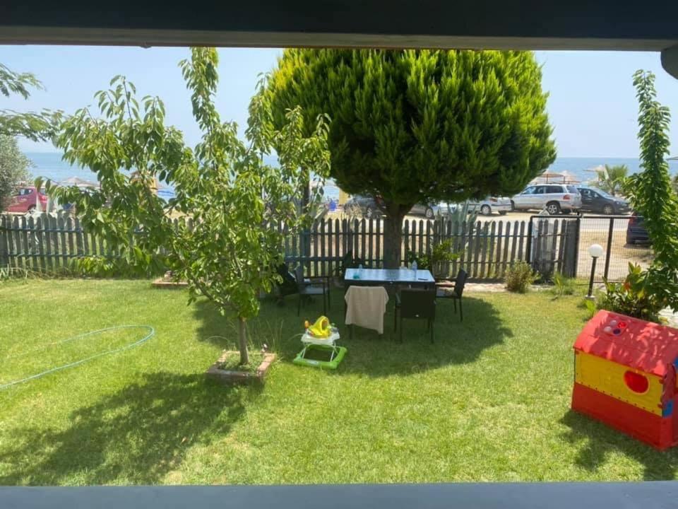 um quintal com uma mesa de pingue-pongue e duas árvores em Villa Borisa em Paralía Avdhíron