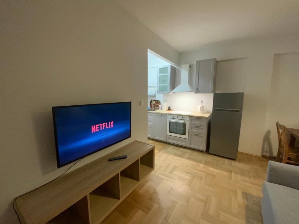 sala de estar con TV de pantalla plana en la pared en Villa Verona en Cracovia