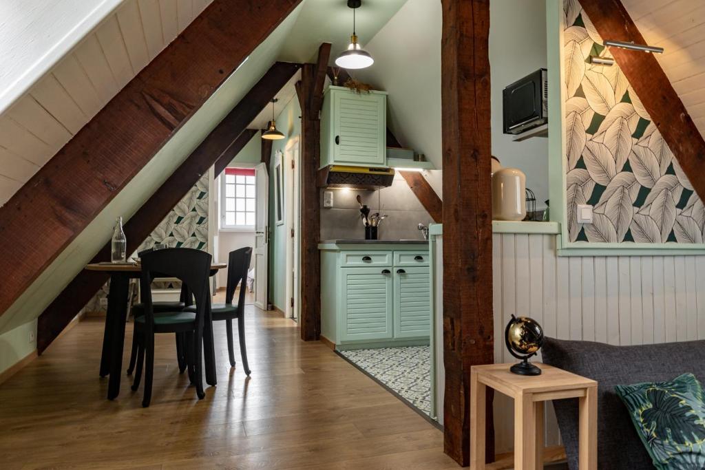 a kitchen and dining room with green cabinets and a table at joli appartement 2 pers dans les remparts de Guérande in Guérande