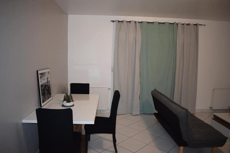 une salle à manger avec une table et des chaises blanches dans l'établissement Le gîte de la palmeraie, à Étauliers