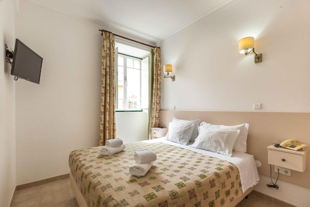 een slaapkamer met een bed met twee handdoeken erop bij Villa Marquez in Vila Real de Santo António