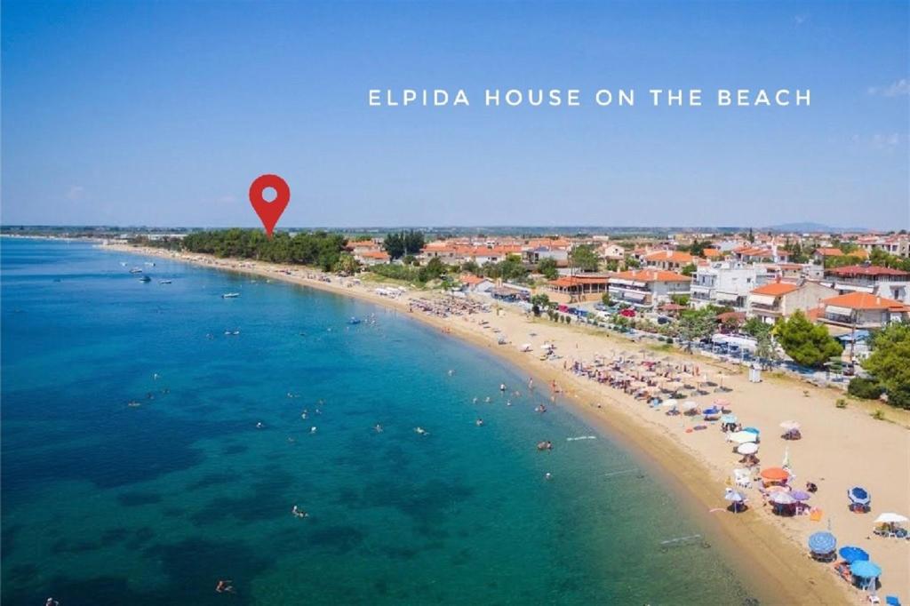 an aerial view of a beach with people on the beach at Elpida House on the Beach (2 bedrooms 6 guests) in Kalivia Poligirou