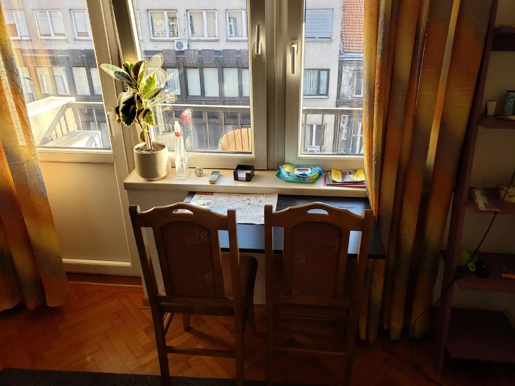 a table and two chairs in front of a window at Cozy room in appartment, with shared bathroom,downtown Belgrade in Belgrade
