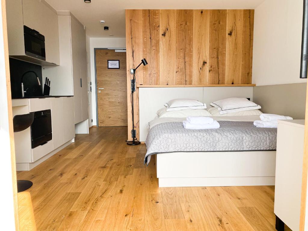 um quarto com uma cama e piso em madeira em Palace 404 em Spindleruv Mlyn