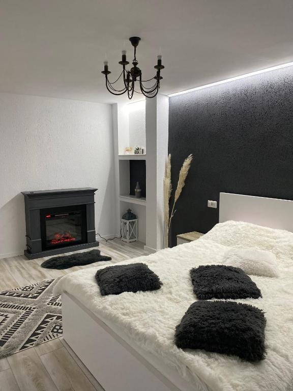 a bedroom with a white bed and a fireplace at Apartament Maria in Alba Iulia