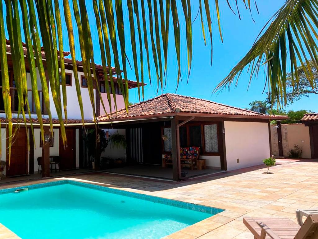 una casa con piscina frente a ella en Loft a 600 metros da praia c piscina em Buzios RJ en Búzios