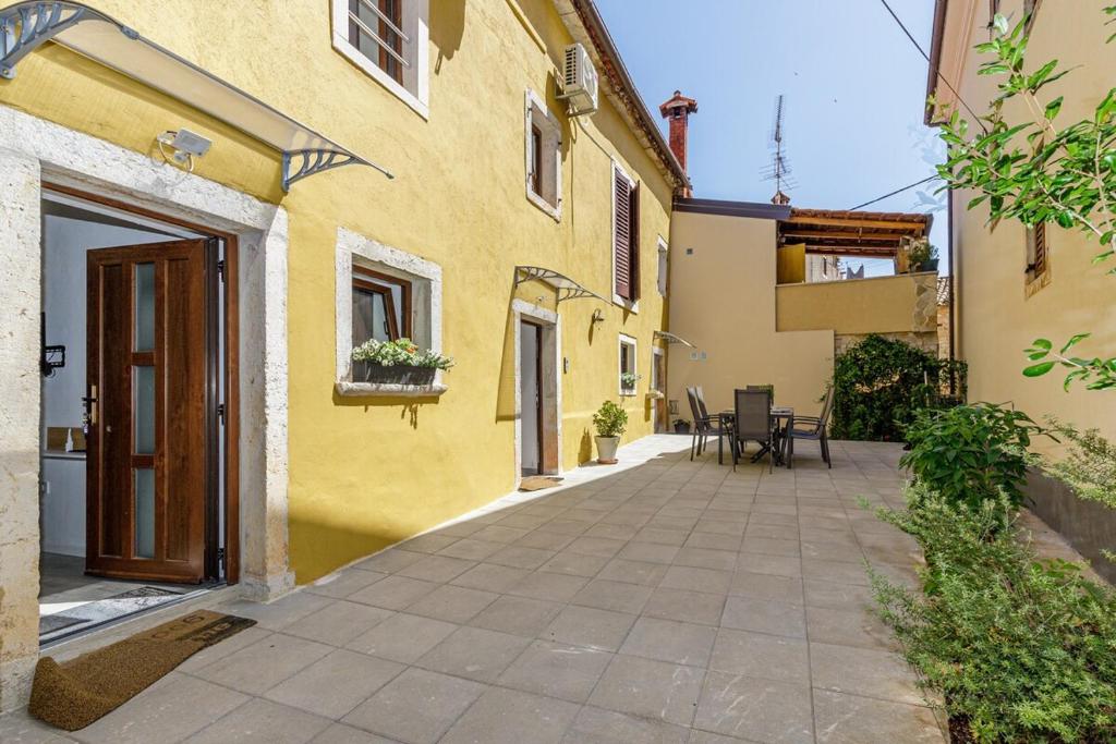 a courtyard of a yellow building with a patio at House Aves 2 in Kaštelir