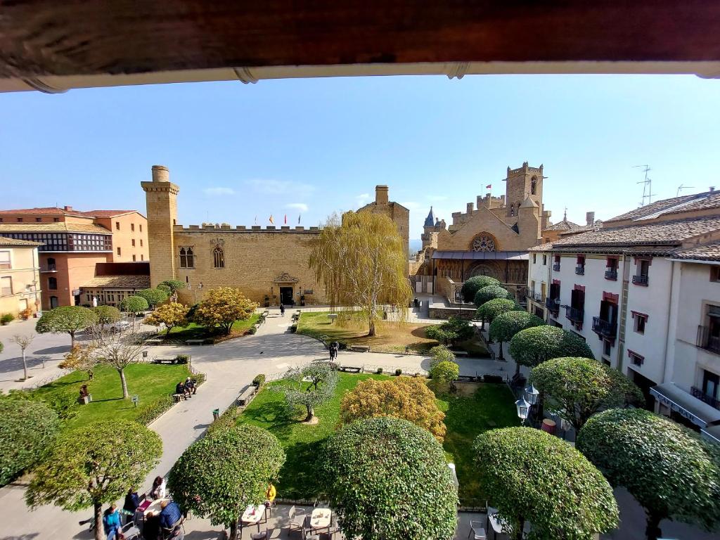 Blick auf einen Innenhof mit Bäumen und Gebäuden in der Unterkunft Apartamentos La Atalaya in Olite