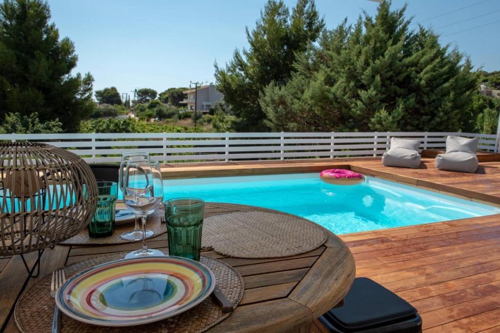 une terrasse avec une table et une piscine dans l'établissement Evaeri villa, à Artemi
