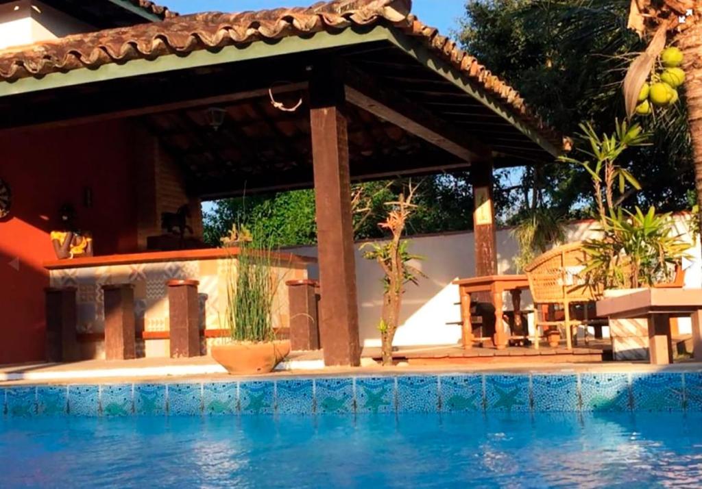 una piscina frente a una casa con pérgola en Incrivel loft proximo a praia c pisc em Buzios RJ, en Búzios
