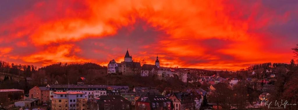 - Vistas a una ciudad al atardecer con un castillo en Neue Unterkunft mit Kamin im Erzgebirge - SZB, en Neuanbau