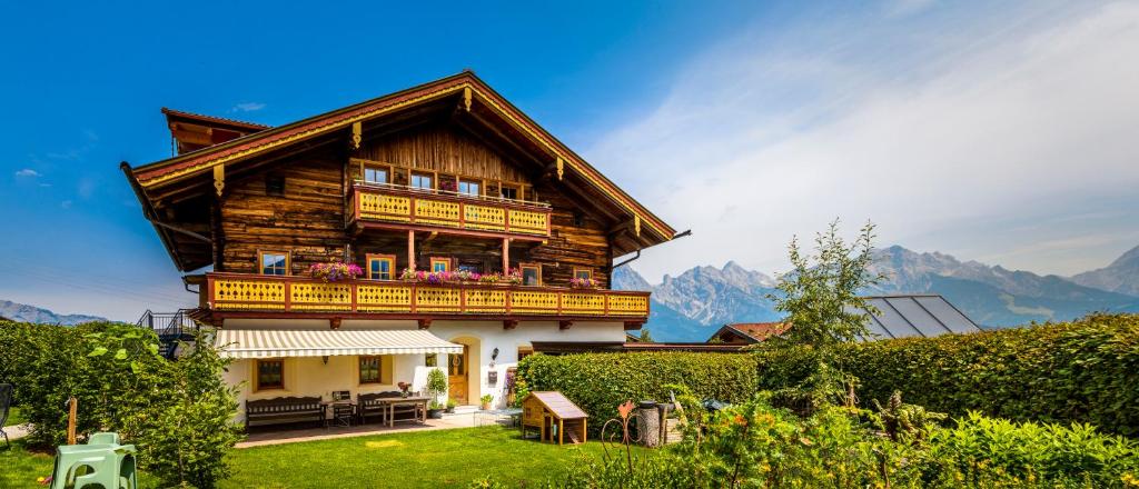 a wooden house with a balcony on the side of it at Ferienwohnung Kracherbauer in Saalfelden am Steinernen Meer