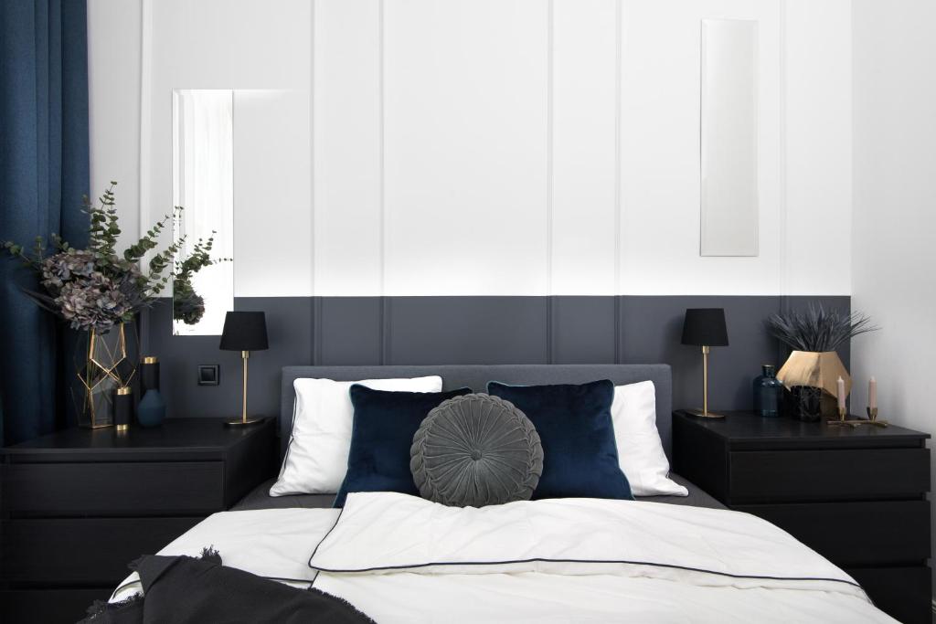 una camera da letto con un letto con cuscini blu e bianchi di Holló 3 Bedroom Downtown Apartment a Budapest