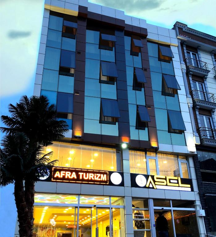 a hotel in a city with a palm tree at TRABZON Asel Suite Otel in Trabzon