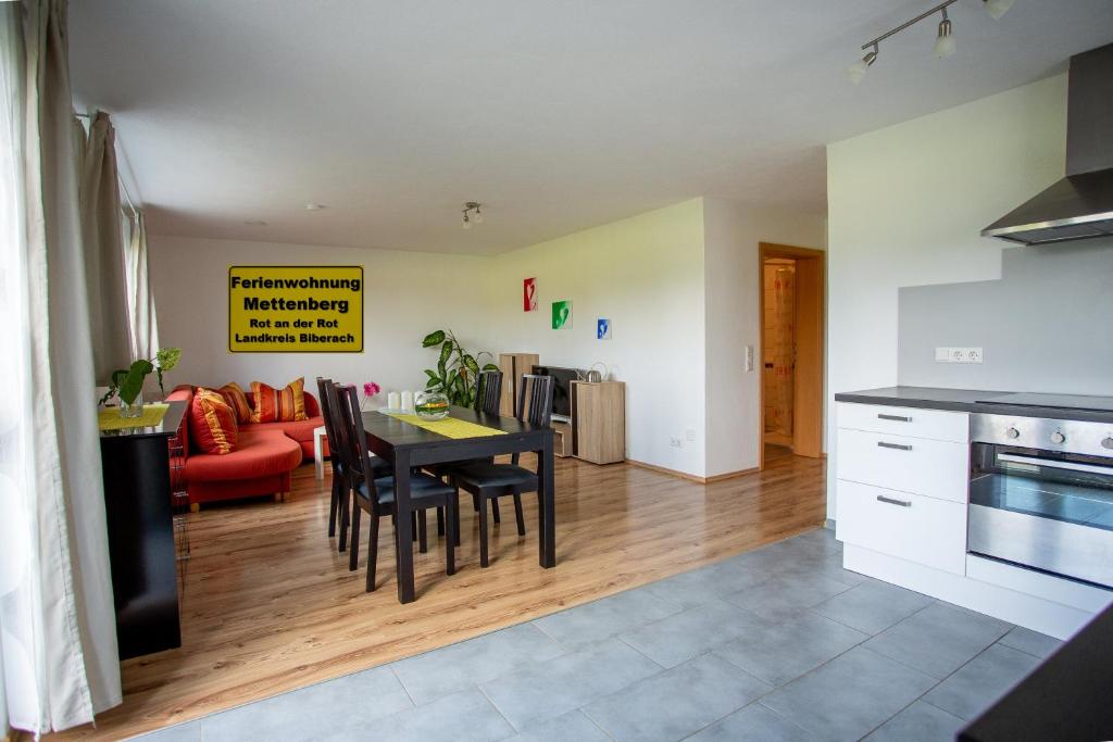 a kitchen and living room with a table and a couch at Ferienwohnung Mettenberg in Rot an der Rot