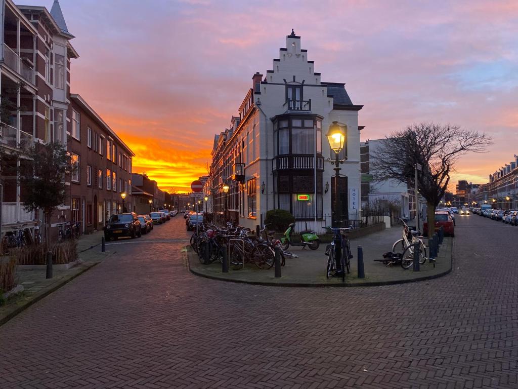 eine Gruppe von Fahrrädern, die bei Sonnenuntergang auf einer Straße geparkt werden in der Unterkunft Hotel 't Sonnehuys in Scheveningen