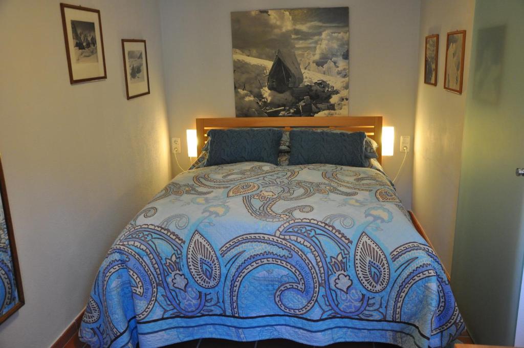 a bedroom with a bed with a blue comforter at Ferienwohnung Bitterling in Marktschellenberg