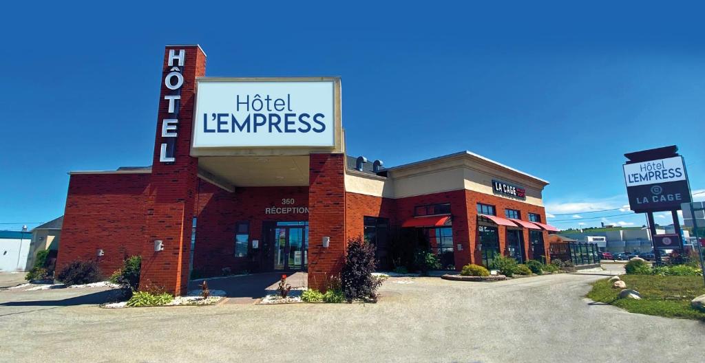 een bord voor hotelvernieuwing aan de zijkant van een gebouw bij Hôtel l'Empress in Rimouski