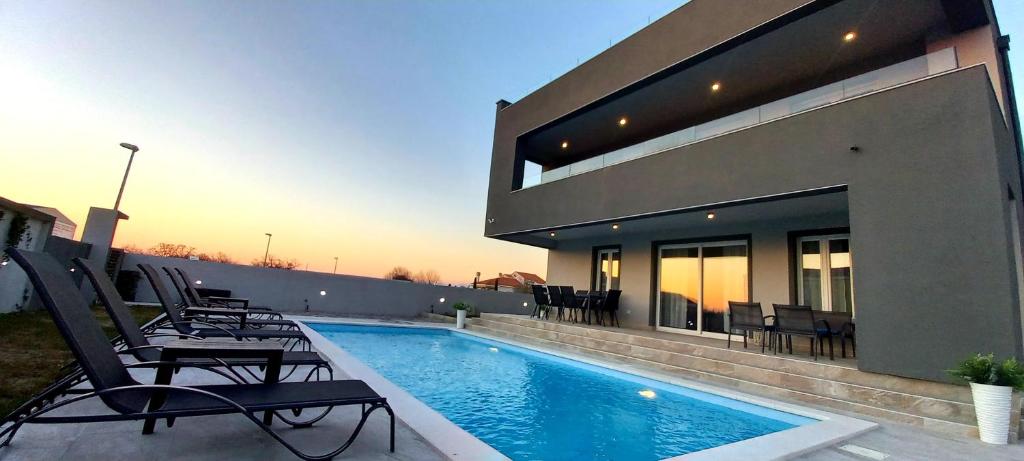 een zwembad voor een huis bij Villa Tia with heated pool in Murvica