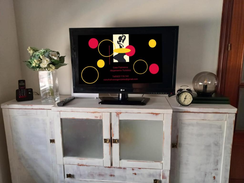 a tv sitting on top of a white cabinet at Casa Flamenca in Castilleja de la Cuesta