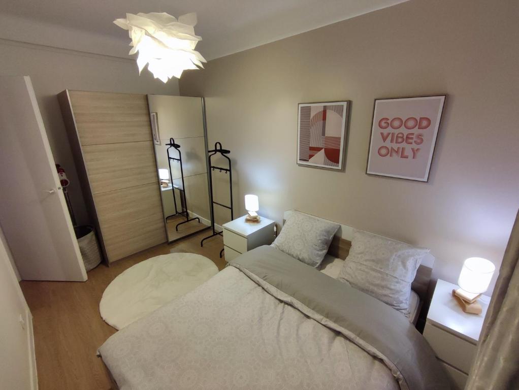 een woonkamer met een bed en een spiegel bij Logement entier:Asnières sur Seine (10mn de Paris) in Asnières-sur-Seine