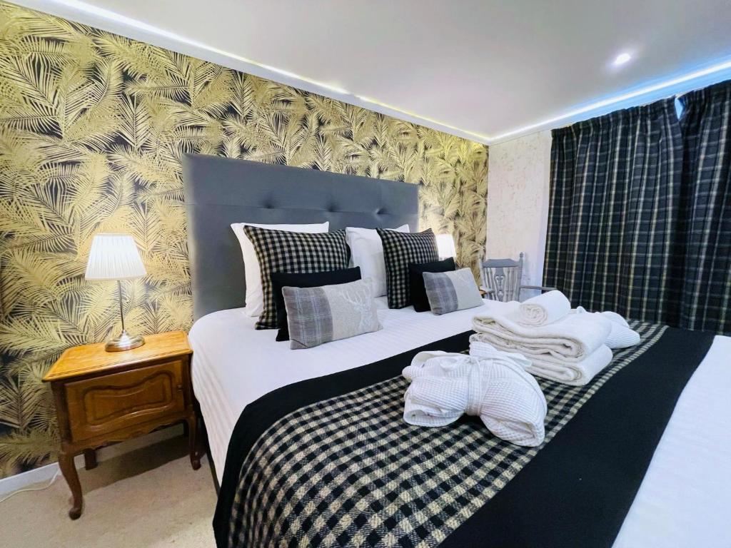 1 dormitorio con 2 camas y toallas blancas. en Chabanettes Hotel & Spa en Auzelles