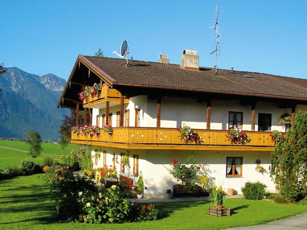 Una casa grande con flores al costado. en Gästehaus Sterrhäusl - Chiemgau Karte, en Inzell