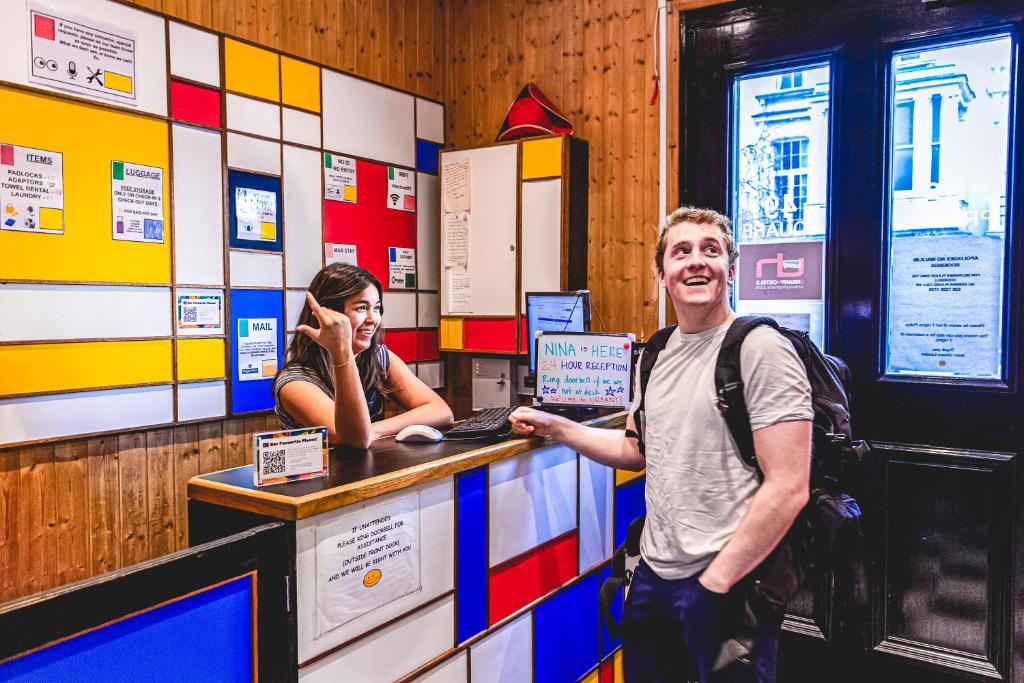 un homme debout devant un comptoir dans un magasin dans l'établissement Urbany Hostel London 18-40 Years Old, à Londres