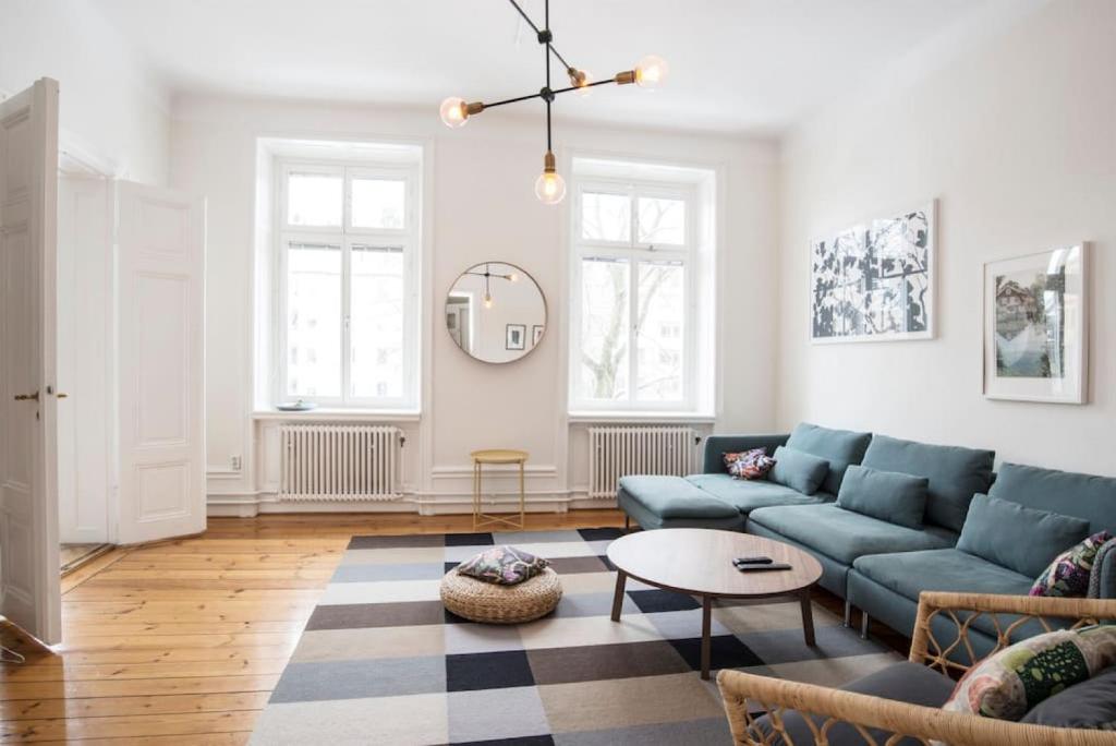 een woonkamer met blauwe banken en een tafel bij Elegant and light 3 room apartment in SoFo 97sqm in Stockholm